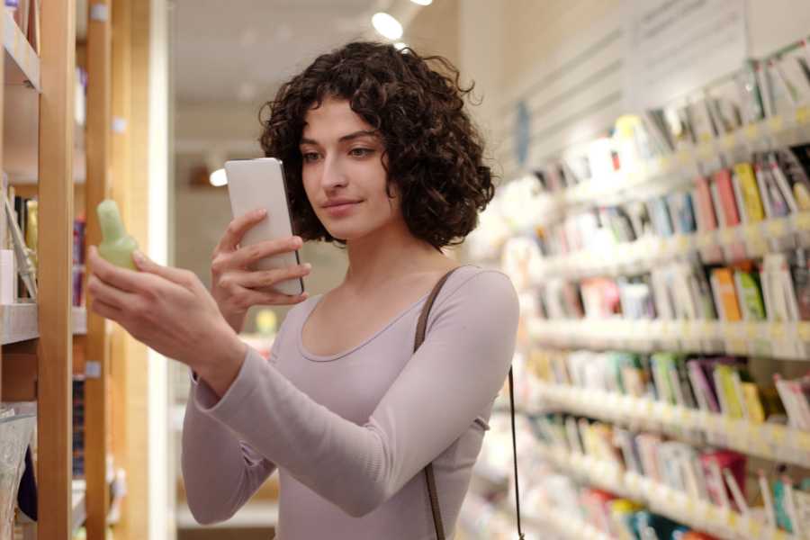 una joven mujer fotgrafía un producto en un comercio